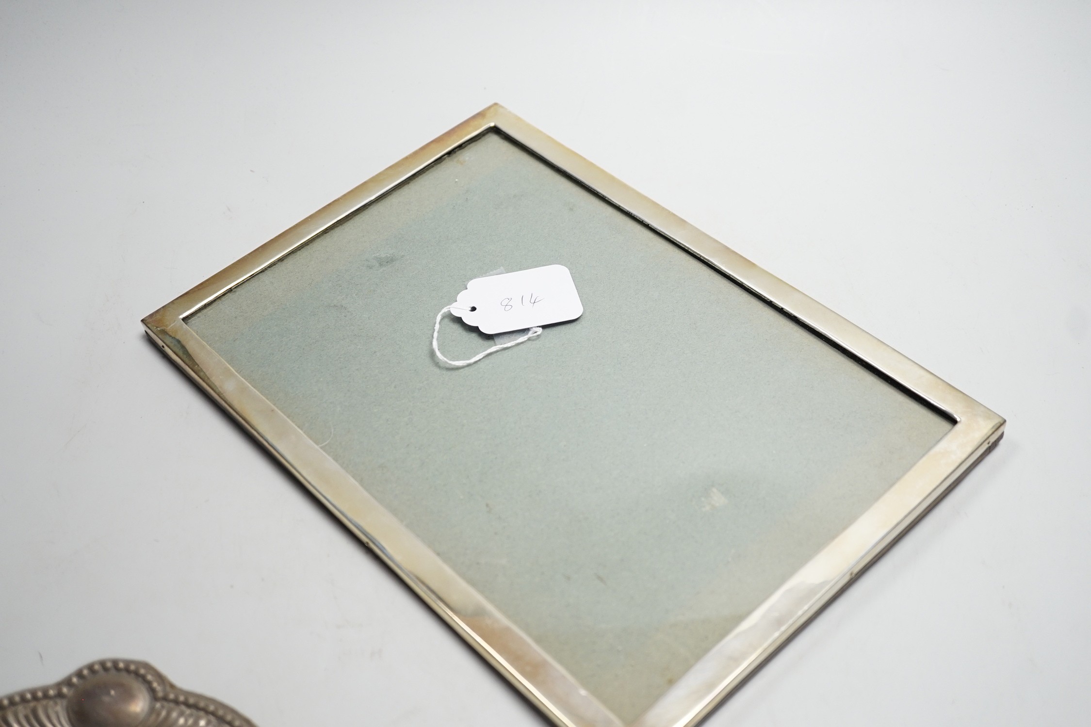 An Edwardian silver mounted rectangular photograph frame, Birmingham, 1908, 30.7cm and a smaller dome topped silver mounted photograph frame.